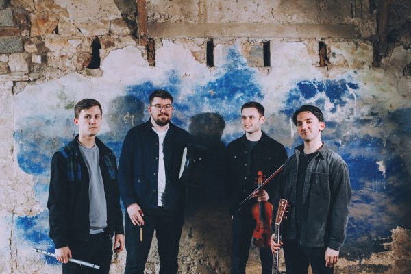 A photo of the four members of Gnoss stood holding their instruments.